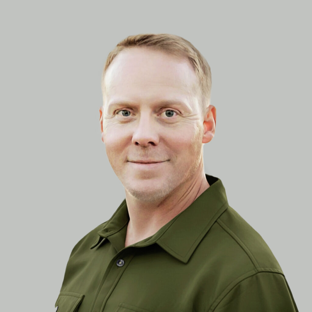 Dr. Michael Smith, MD (Medical Doctor) in a studio portrait against a light gray background, wearing an olive green collared shirt.